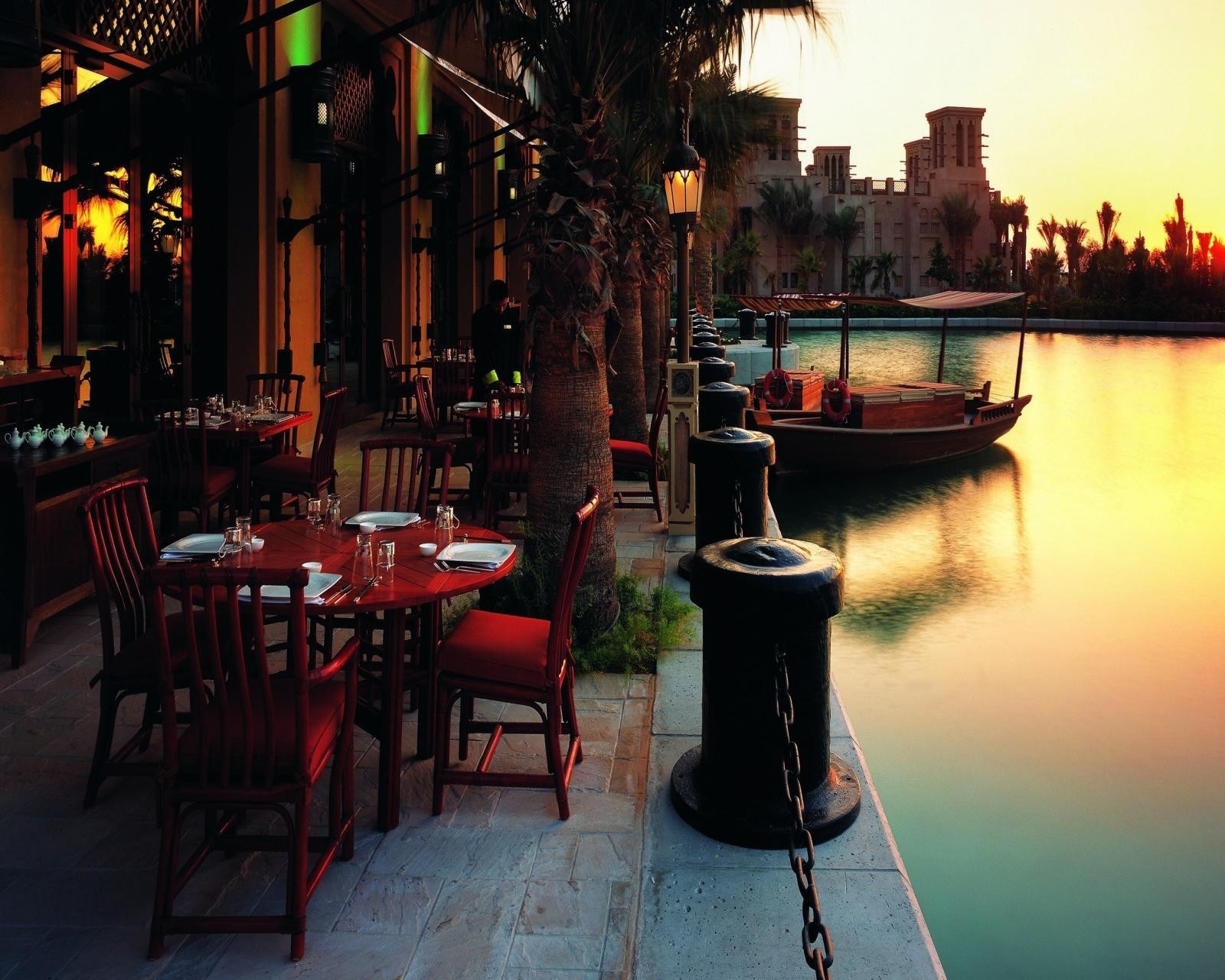 Tische und stühle stehen am ufer eines flusses (strand, dubai, restaurant, vae, uae)