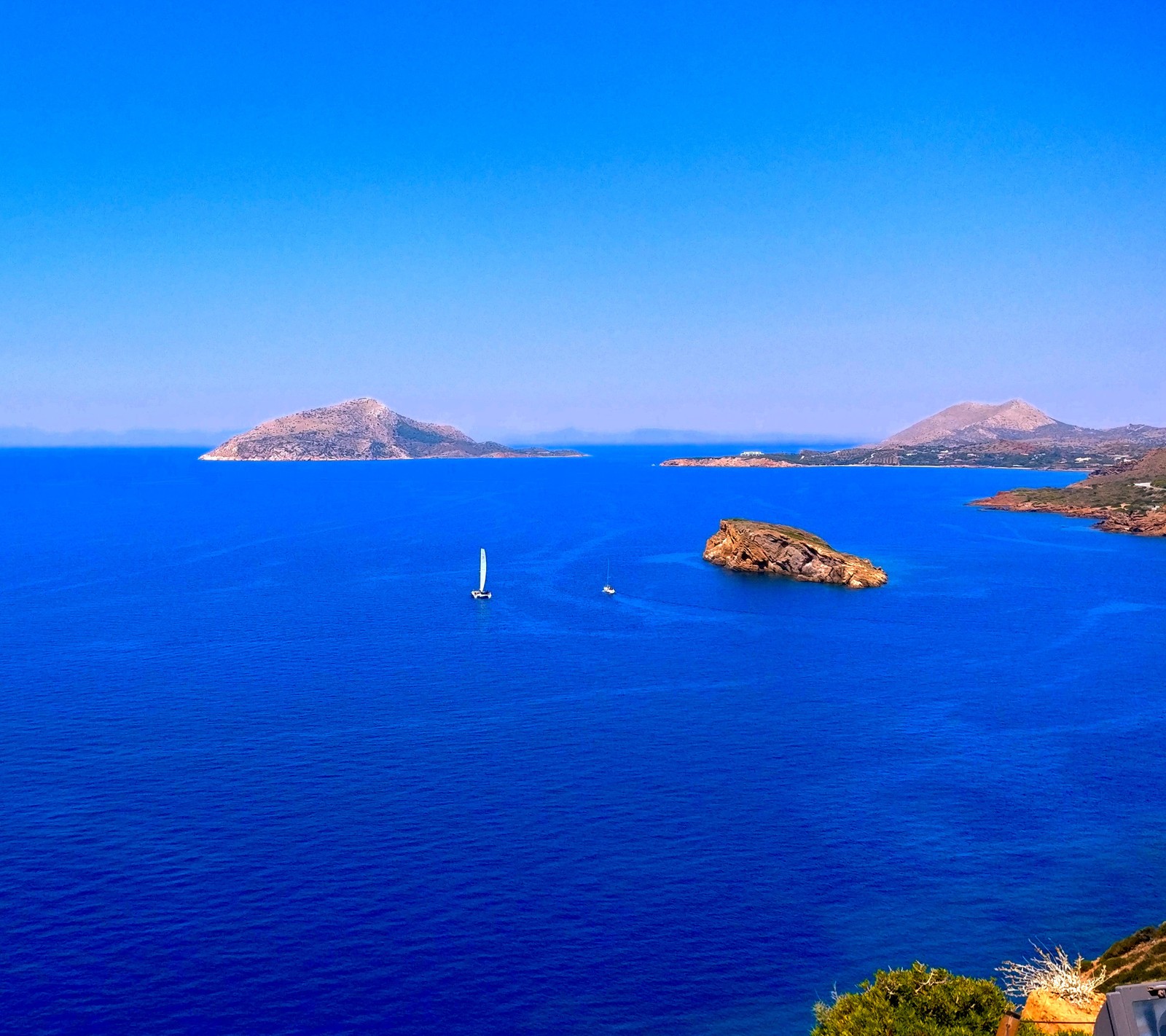 Vista aérea de un cuerpo de agua con un barco en el medio (azul, grecia, festivo, paisaje, naturaleza)