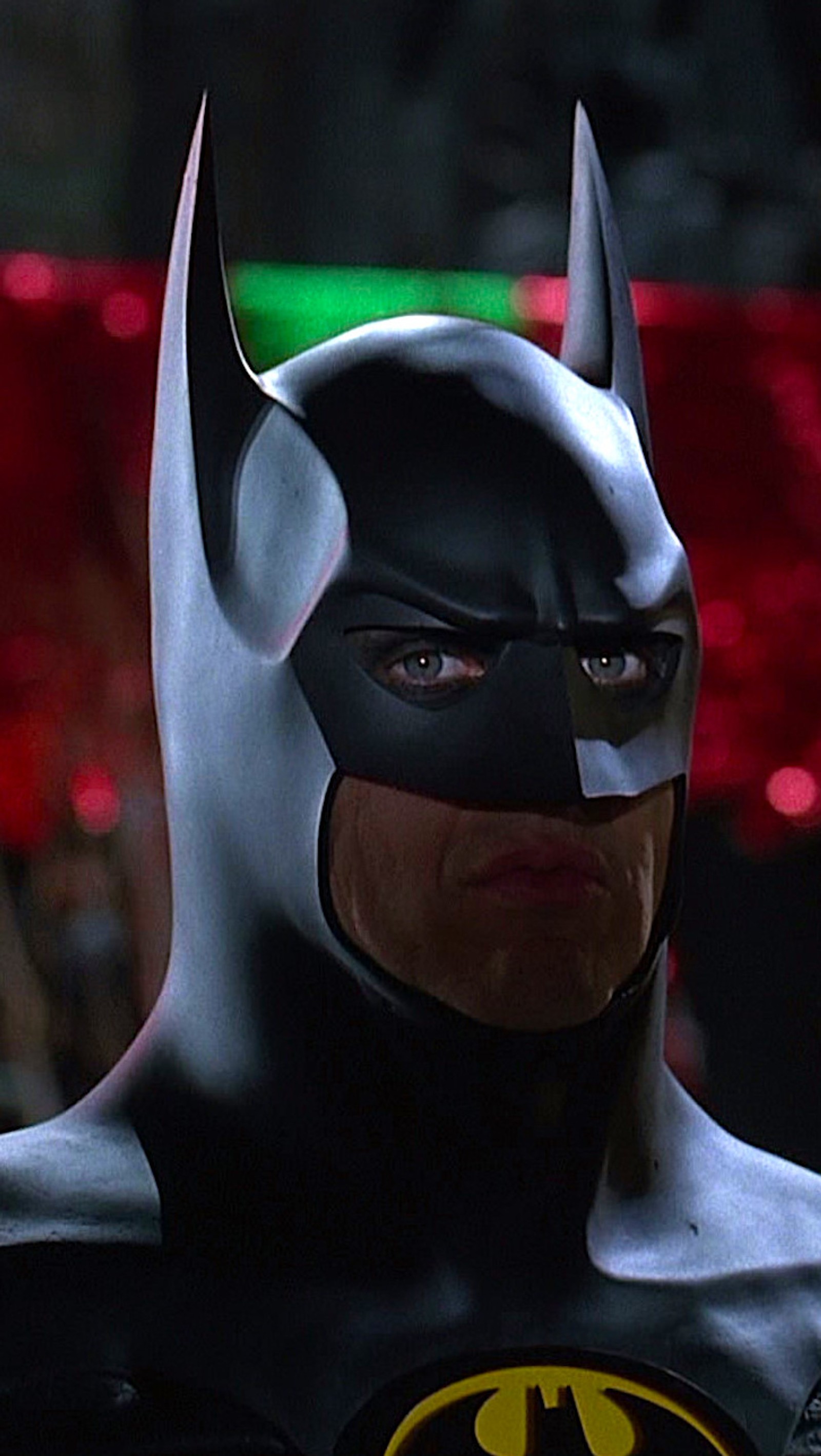 Batman in a batman costume with a green light behind him (batman, burton, keaton, returns)