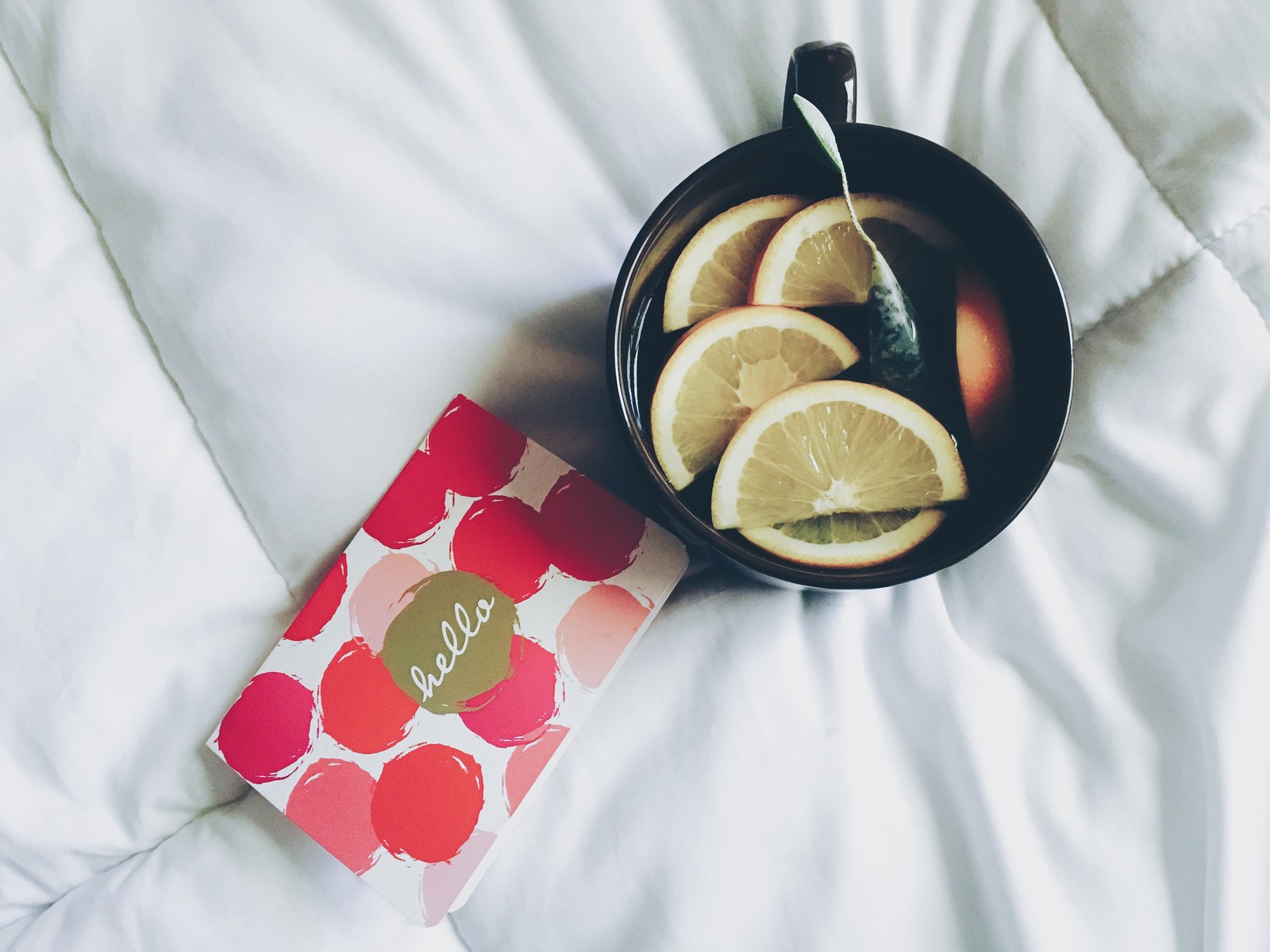 Hay un tazón de frutas y un libro en una cama (lima, lime, cítricos, comida, lima clave)