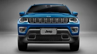 Vista frontal de un jeep azul con parrilla distintiva y iluminación automotriz