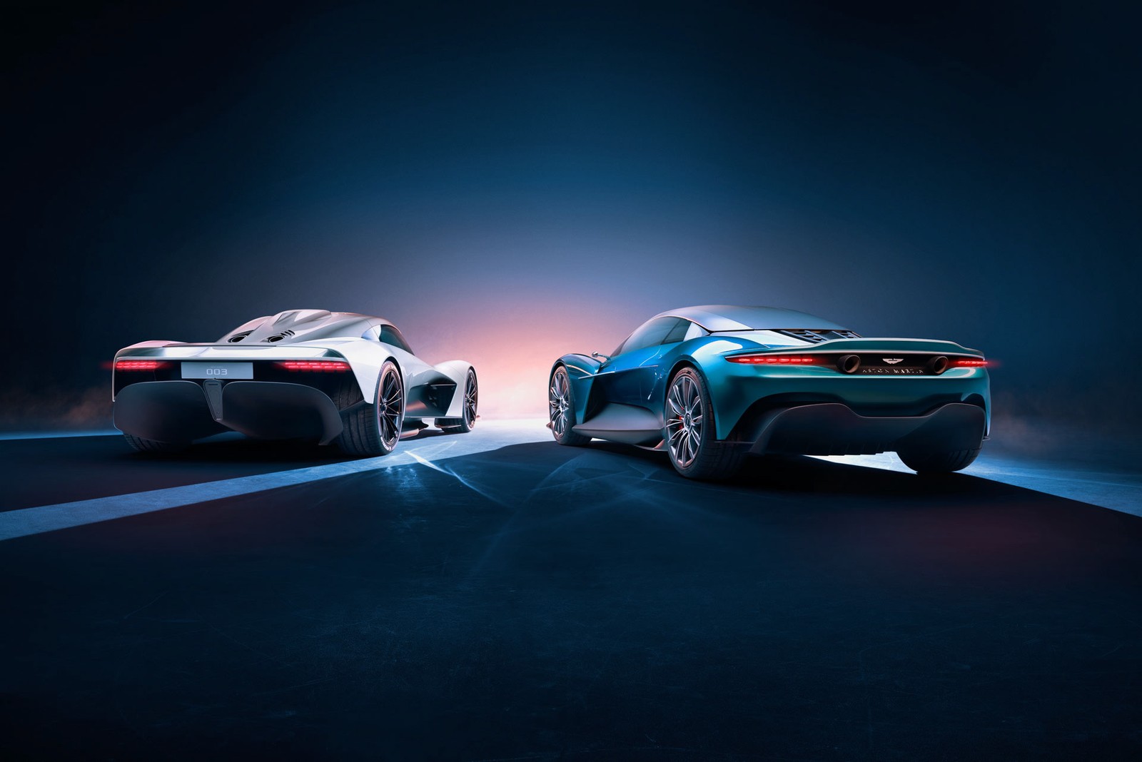 Deux voitures sont présentées côte à côte sur un fond sombre (supersportive, aston martin, voiture de sport, voiture, voiture conceptuelle)