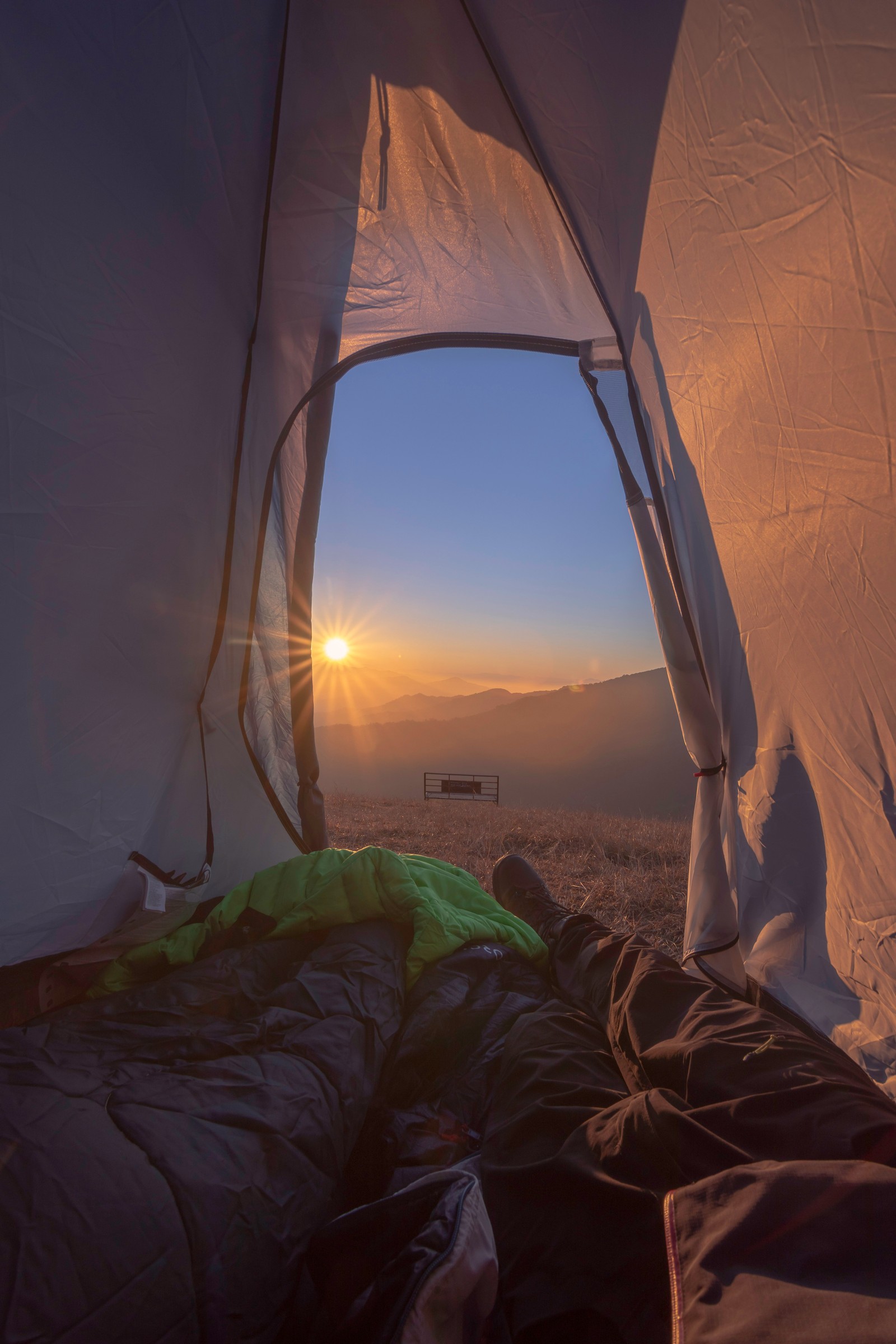 Vue aérienne d'une personne dormant dans une tente avec le soleil couchant (tente, camping, matin, chambre, ensoleillement)