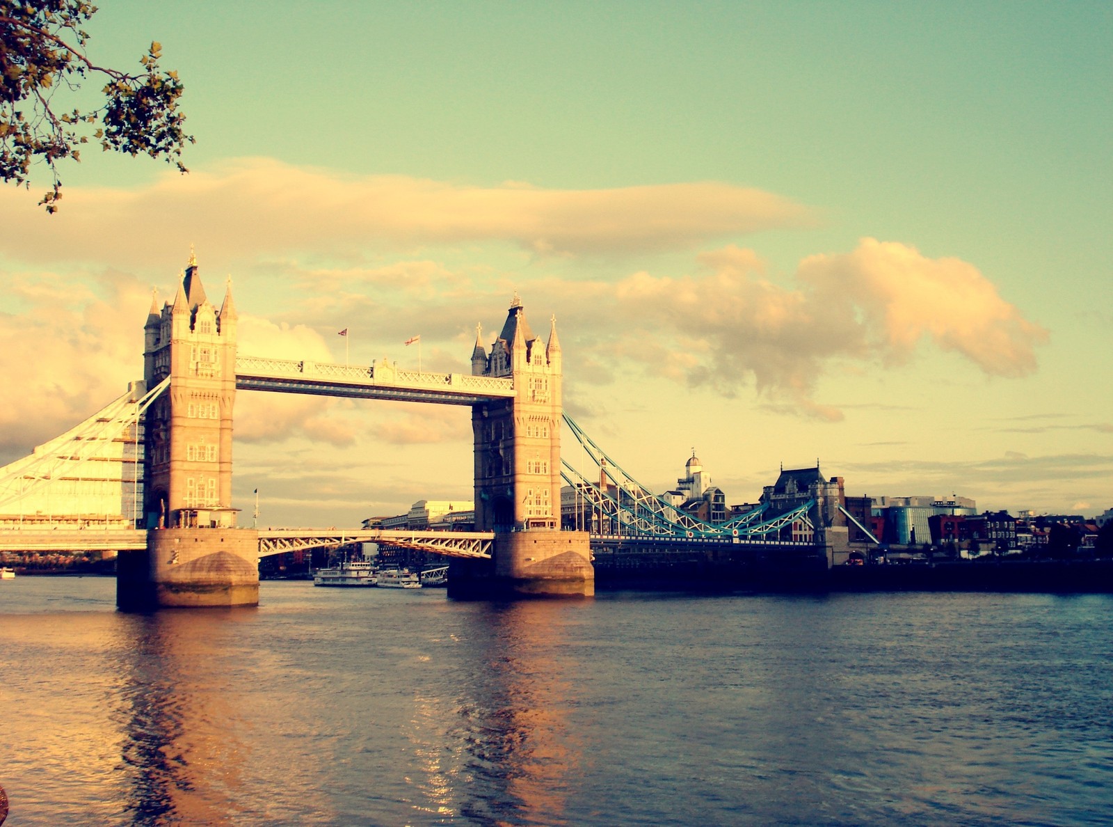 Uma ponte sobre a água com um barco ao fundo (tower bridge, rio tâmisa, london bridge, torre de londres, ponte)