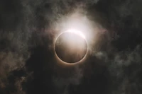 Celestial Eclipse: The Moon Silhouetted Against a Dramatic Sky