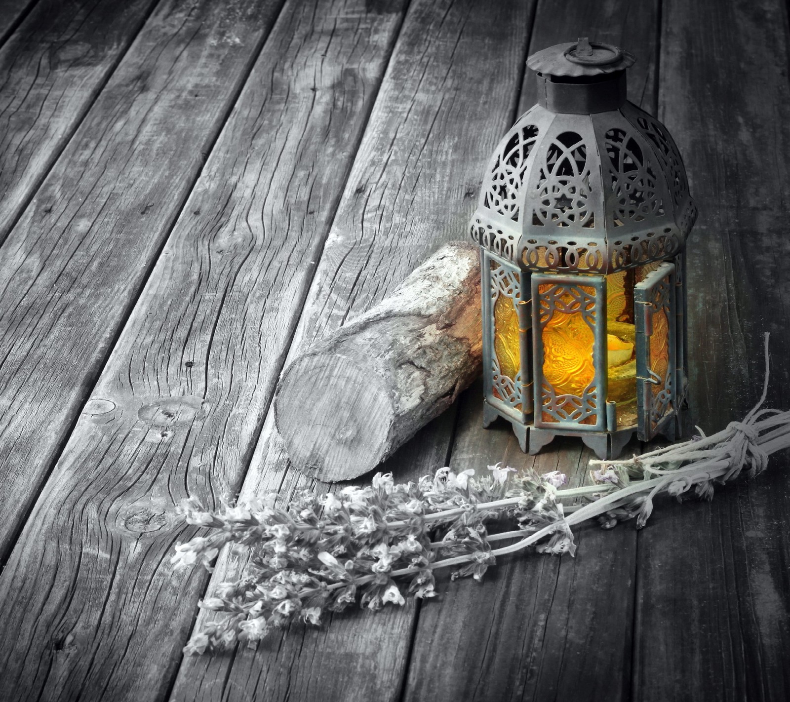 A close up of a lantern on a wooden floor with a rock (lantern, lavender, wood)