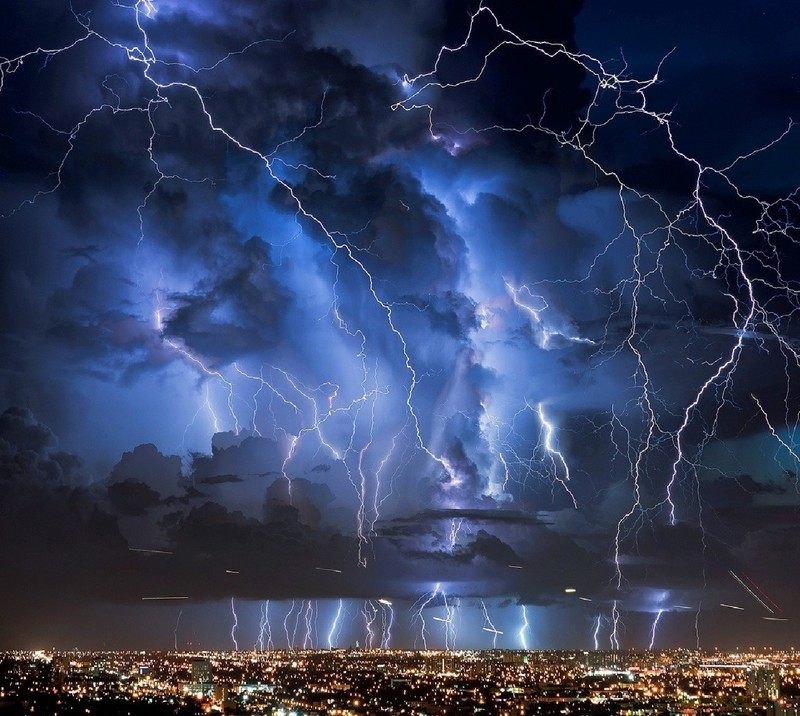 Blitze schlagen über eine stadt bei nacht mit einem dunklen himmel (natur)