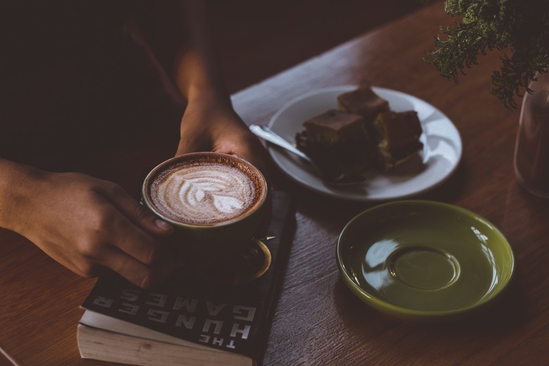 Кто-то держит чашку кофе и книгу на столе (кофе, кафе, латте, latte, капучино)