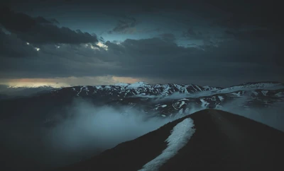 Chaîne de montagnes d'hiver sous un ciel bleu avec des nuages et de la brume