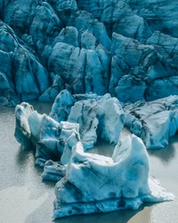 Türkise Gletscher-Eisberge umgeben von ruhigem Wasser