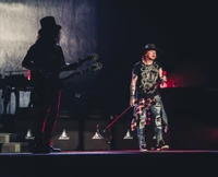 Guns N' Roses interpreta "Don't Cry" durante la gira Not in This Lifetime en Houston, con Axl Rose y Slash en un escenario dramático.