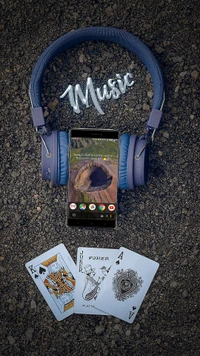 Escuchando música con auriculares y un teléfono inteligente rodeado de cartas de juego