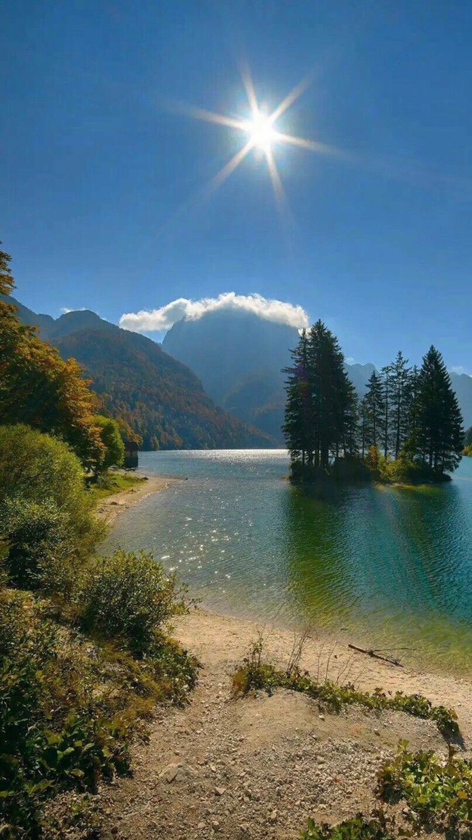 Vista aérea de um lago com uma montanha ao fundo (flúmen, sol)