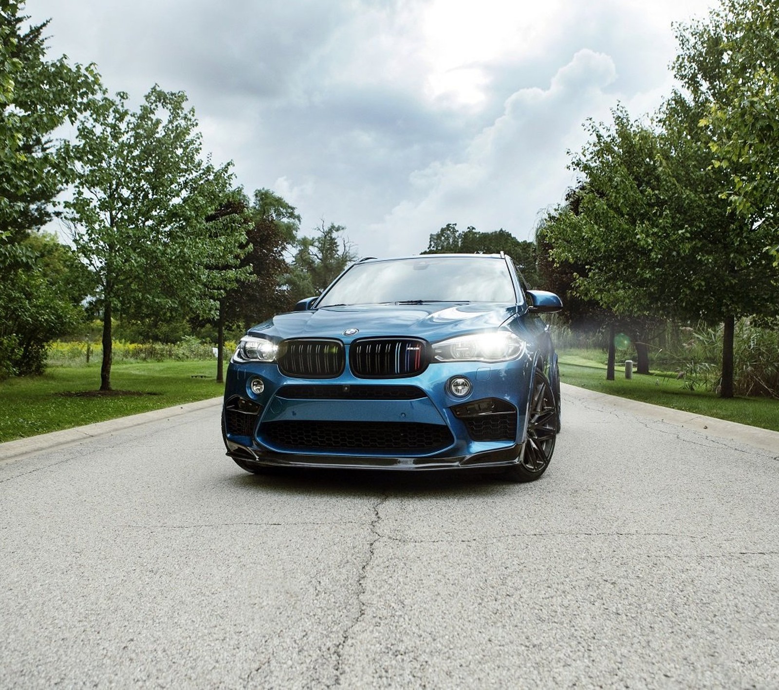 A close up of a blue bmw suv parked on a road (blue, bmw, car, x5)