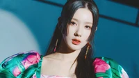 Miyeon from (G)I-DLE in a vibrant floral outfit, exuding elegance and charisma.