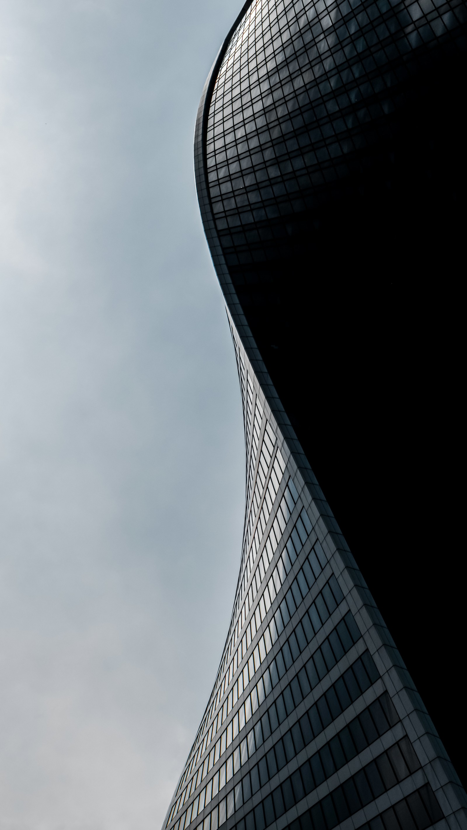 Vue aérienne d'un grand bâtiment avec un avion volant dans le ciel (point de repère, bâtiment, gratte ciel, nuage, tour)