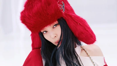 Jennie from BLACKPINK in a striking red fur hat, showcasing a bold and captivating look.