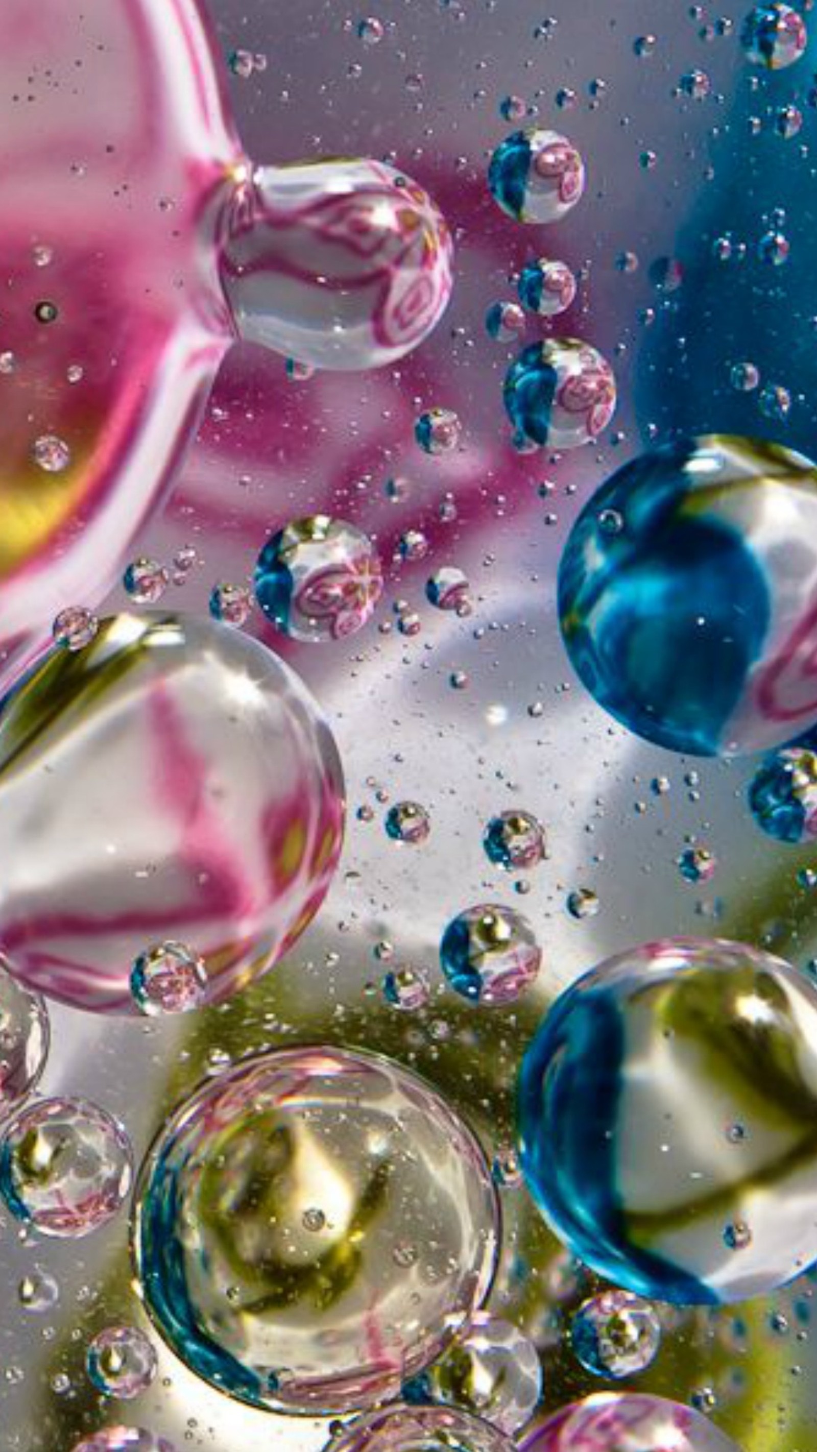 A close up of a bunch of bubbles in a bowl of water (blue, bubbles, green, other, pink)