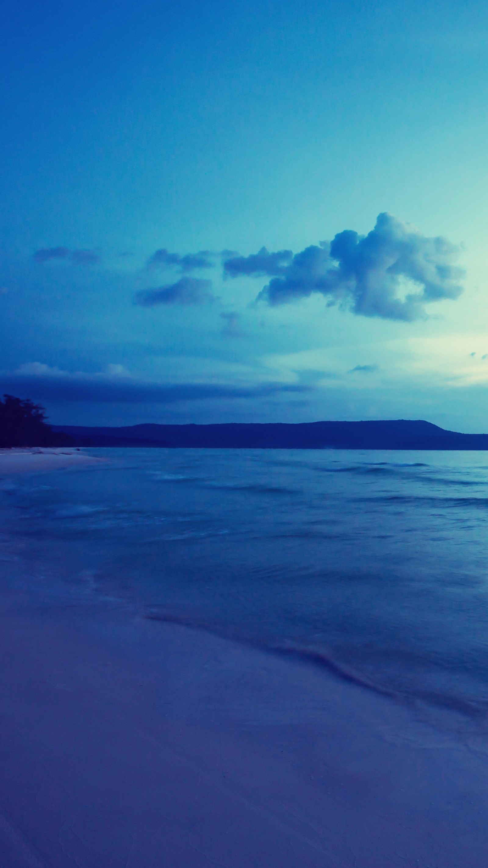 Une planche de surf solitaire sur la plage au crépuscule (plage, bleu)