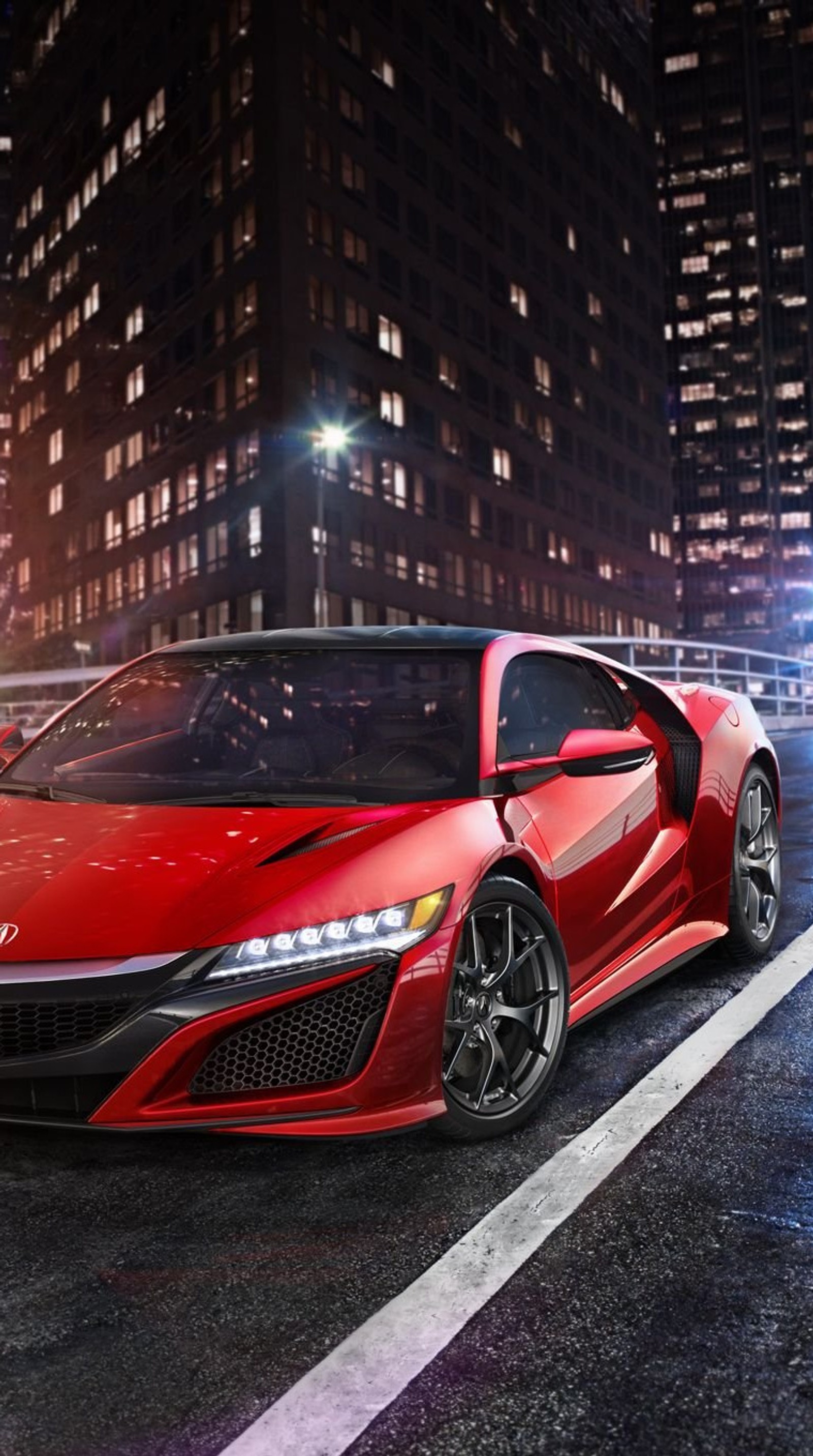 A red sports car driving down a city street at night (acura, car, future)