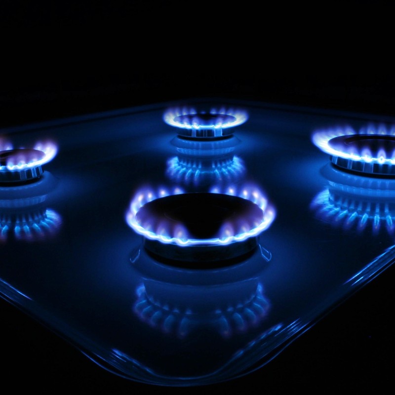 A close up of a blue flame burner on a stove top (fx, he)