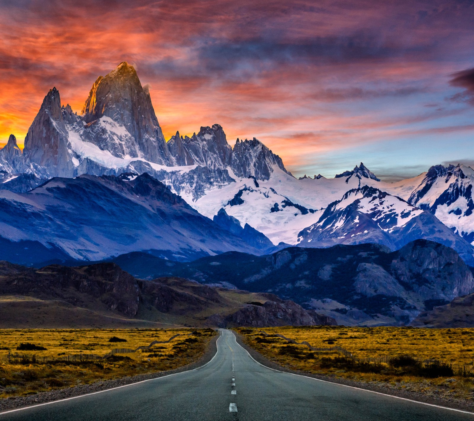 Una vista de una carretera que lleva a una cadena montañosa con una puesta de sol (montaña, camino, amanecer)