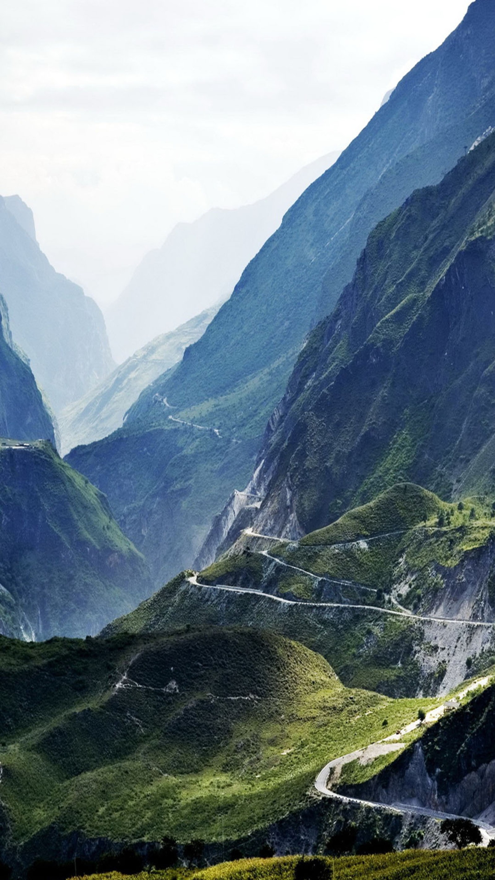 Il y a une route sinueuse traversant une vallée dans les montagnes (route, vallée)