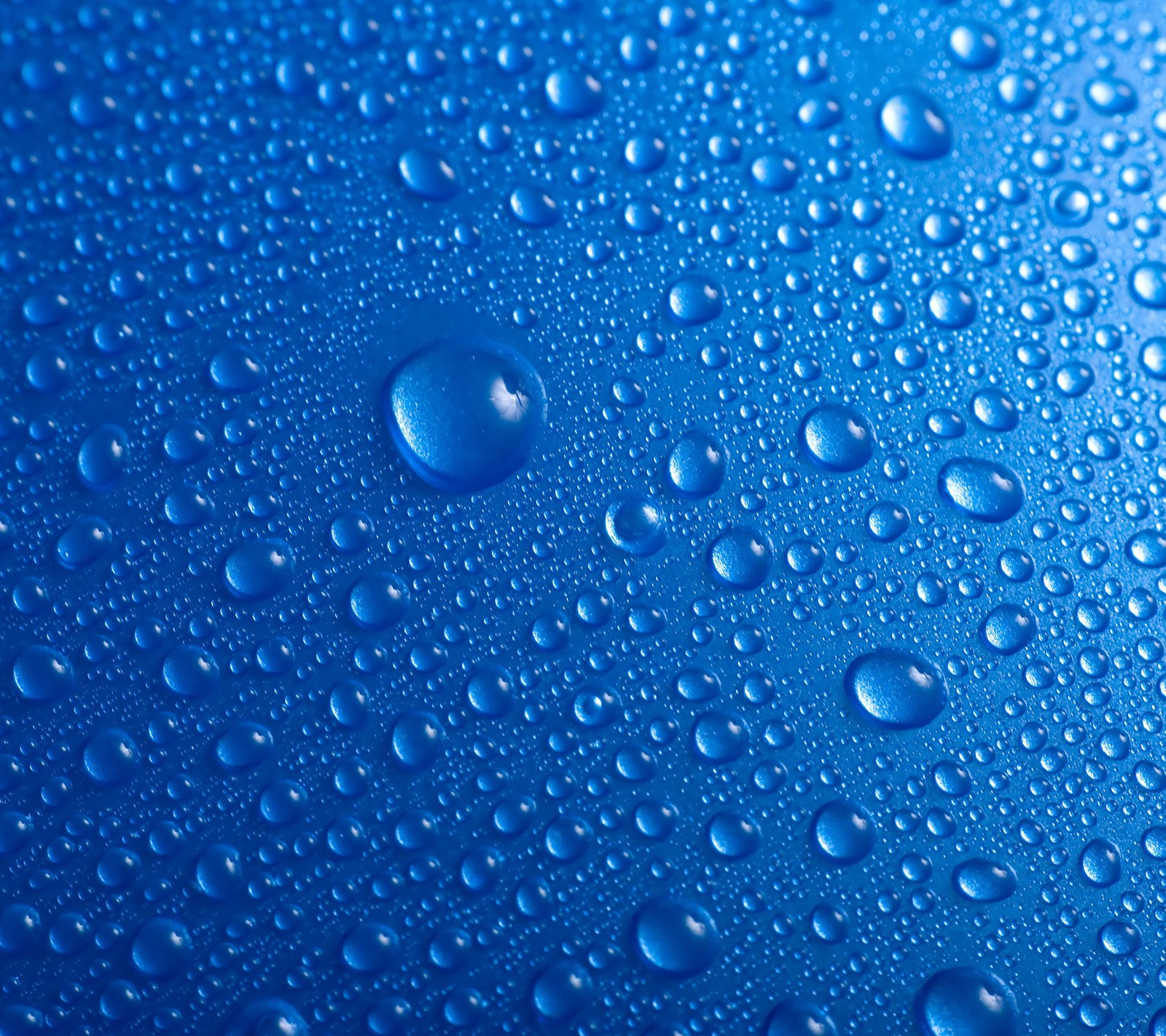 Un primer plano de gotas de agua en una superficie azul (azul, rocío, gotas, lluvia, mojado)