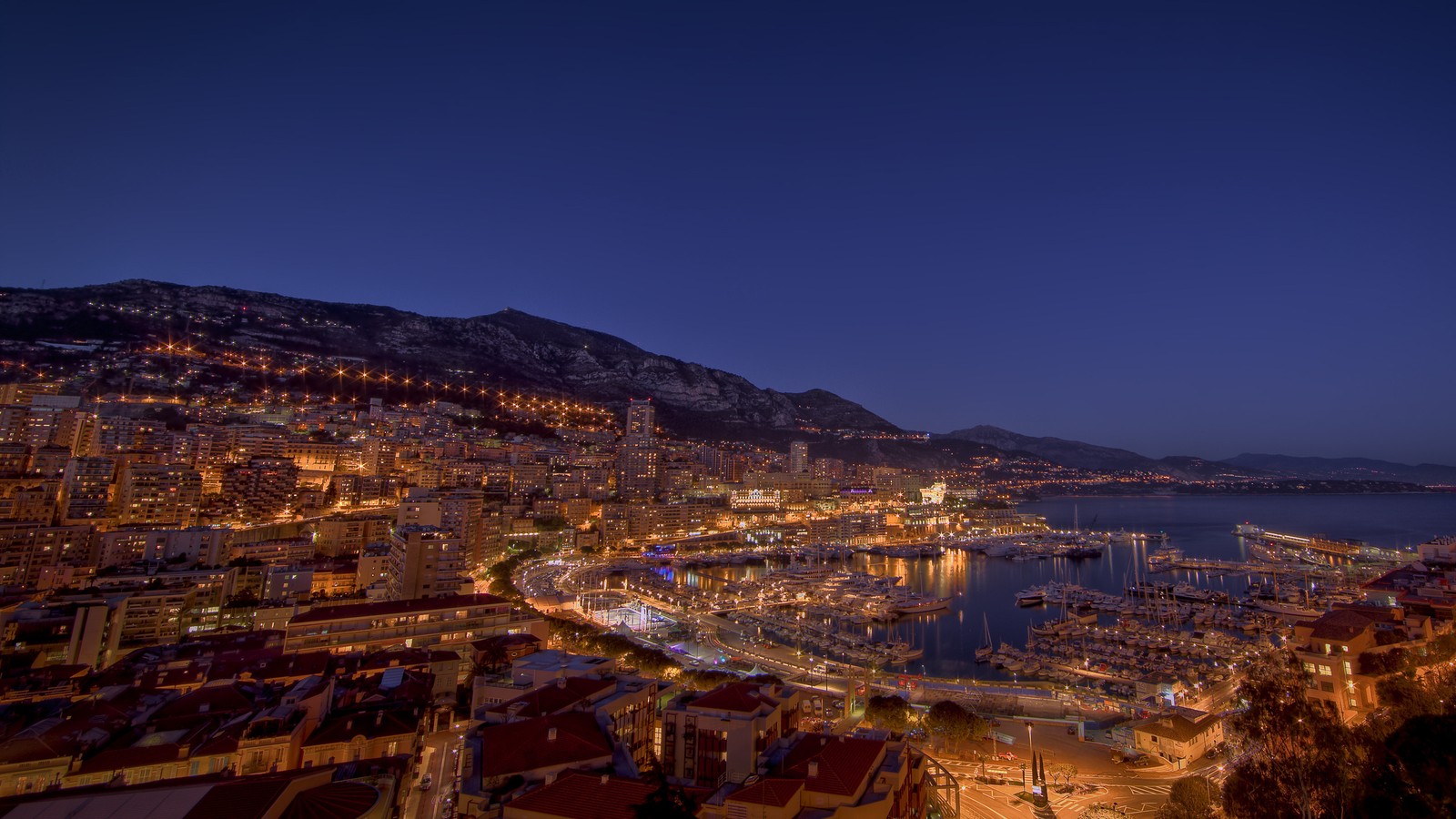 Uma vista da cidade de mônaco à noite do topo da colina (noite, cidade, paisagem urbana, edifício, mar)