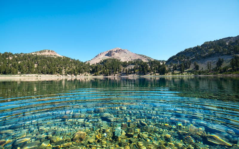 Ясное озеро с камнями и водой в нем (lake helen, lassen national forest, калифорния, california, mount lassen)