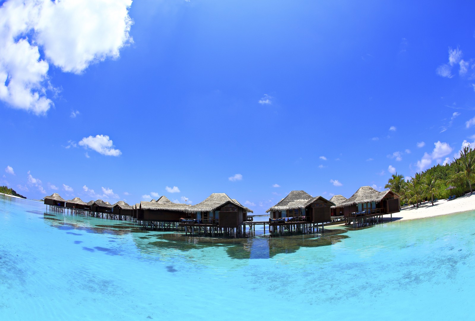 Uma vista de uma praia com uma cabana e um barco na água (maldivas, mar, natureza, água, recursos hídricos)