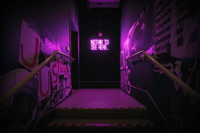 Neon Sign Illuminates Winding Stairs in Violet Hues