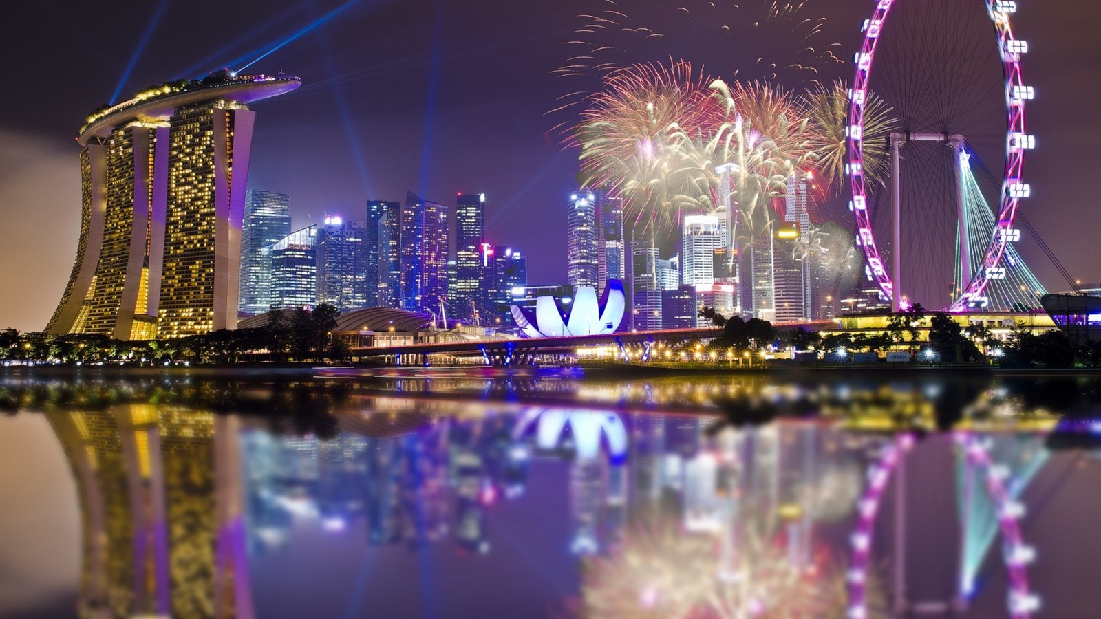 Fogos de artifício no céu sobre uma cidade com uma roda-gigante (singapore flyer, viagem, ano novo, paisagem urbana, reflexo)