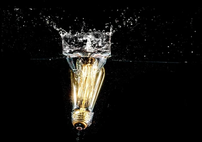 Glühlampe, die in Wasser eingetaucht ist und Dunkelheit erhellt