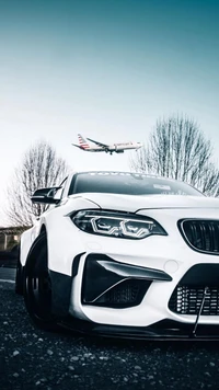 Sleek White Sports Car with a Jet in the Background