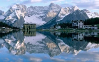 Serene Reflexion der Dolomiten: Ein Gletschersee umgeben von majestätischen Bergen.