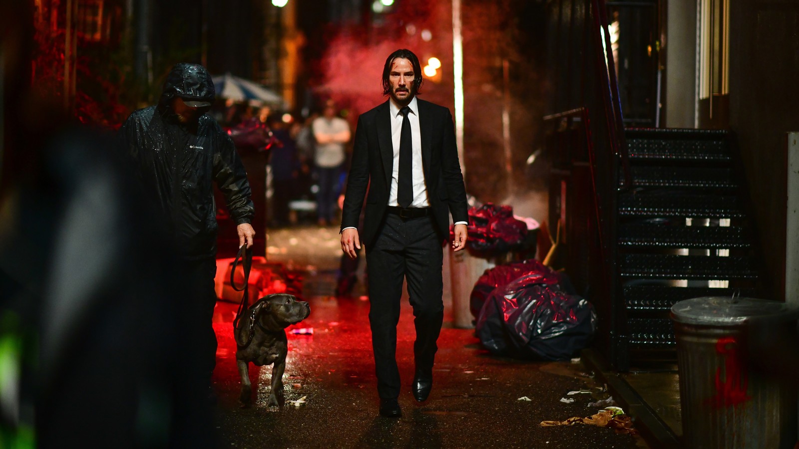 На улице идет мужчина в костюме и галстуке (джон уик 3, john wick 3, фильм, собака, киану ривз)