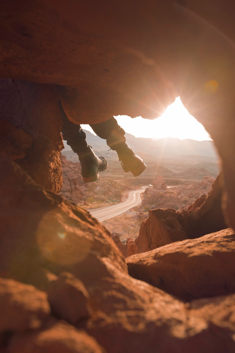 Uma pessoa está em pé sobre uma pedra com uma câmera (rocha, formação, luz solar, geologia, cânion)