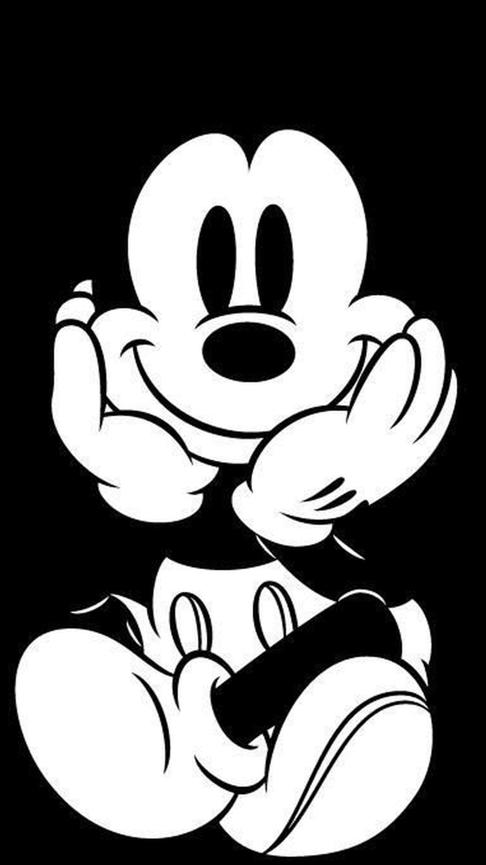 A black and white image of a mickey mouse sitting on the ground (black, mickey, mouse, white)