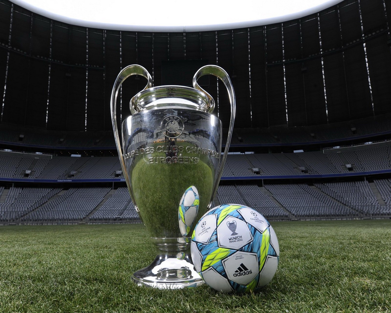 Il y a un ballon de football et un trophée sur l'herbe (ligue des champions, champions league, football)