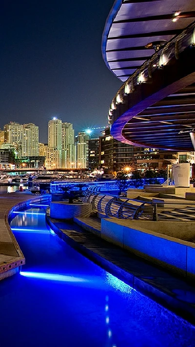 Vista nocturna encantadora con vía fluvial iluminada y horizonte de la ciudad