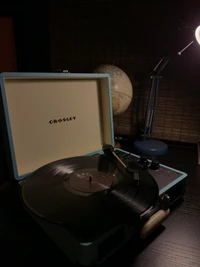 Tocadiscos Crosley con disco de vinilo en una configuración de escritorio elegante