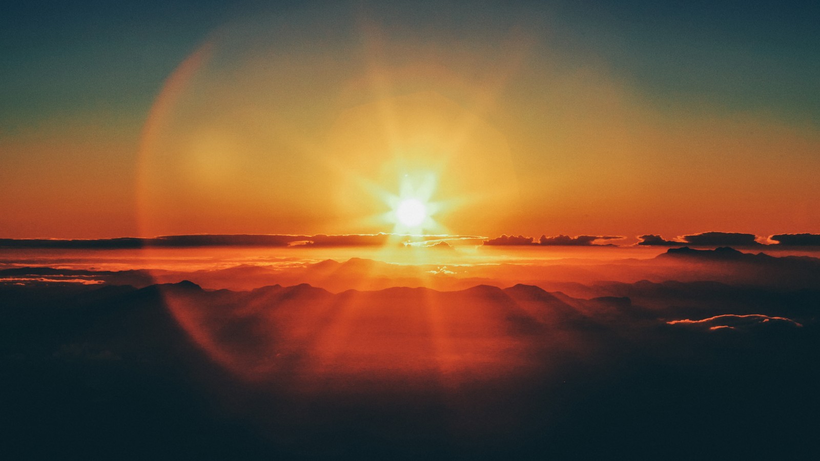 Una vista del sol saliendo sobre las nubes y las montañas (atardecer, cielo, nubes, escenario)