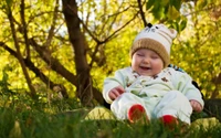 Joyful Infant in Nature Under Tree Canopy