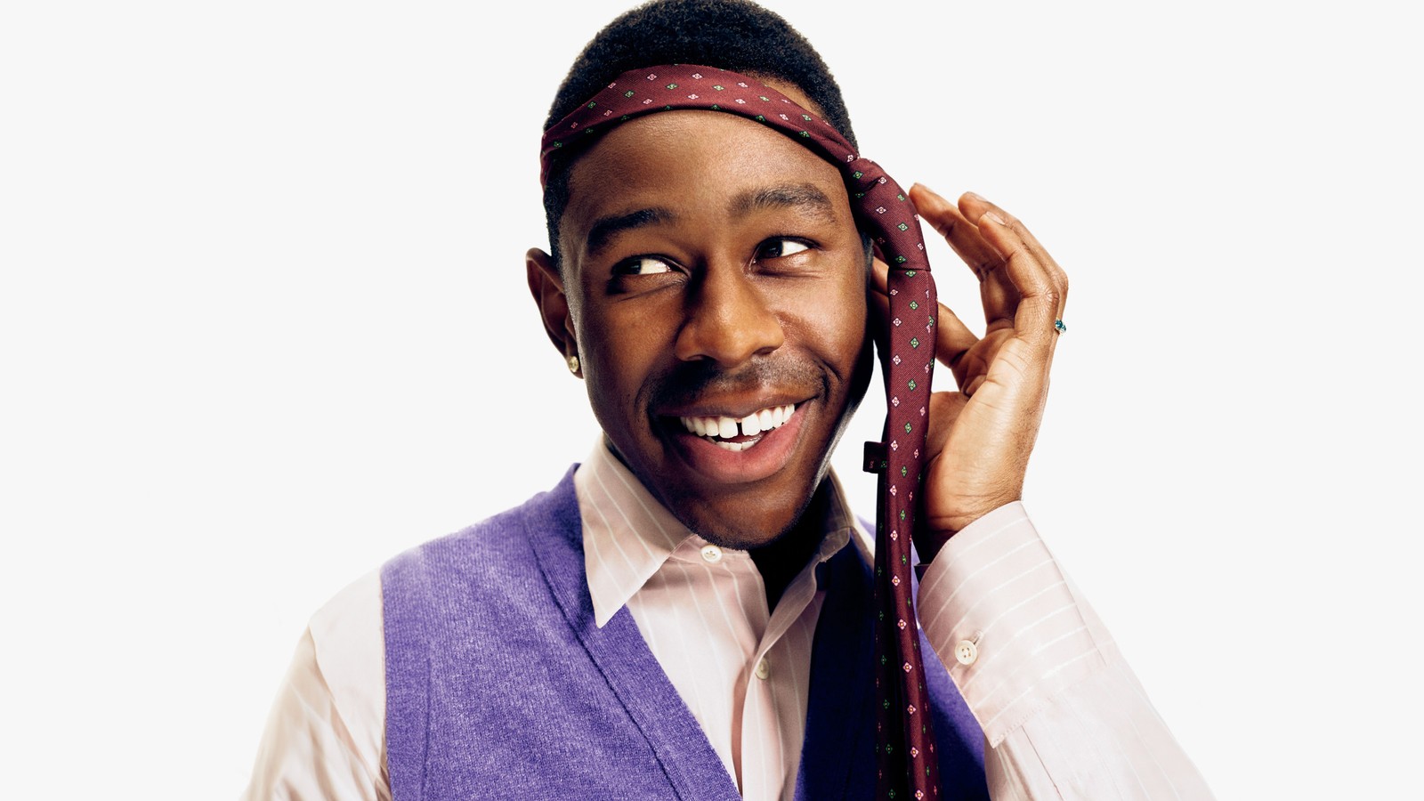 Homem sorridente de colete e gravata levantando uma gravata para a cabeça (tyler o criador, tyler the creator, retrato, rapper americano, 5k)