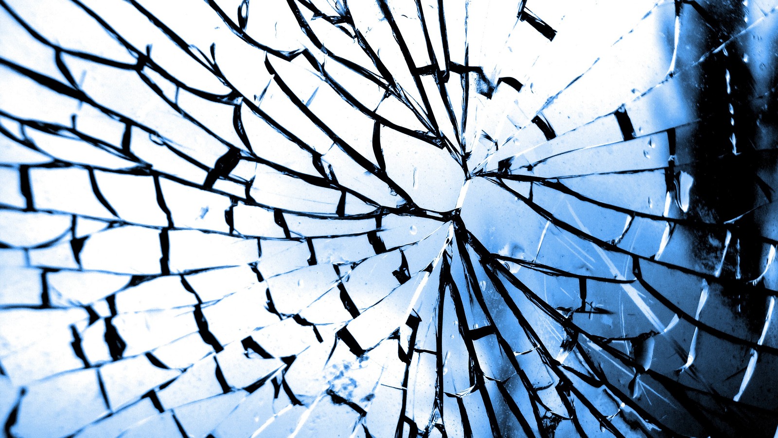 A close up of a broken glass window with a blue sky in the background (mirror, window, glass, pattern, line)