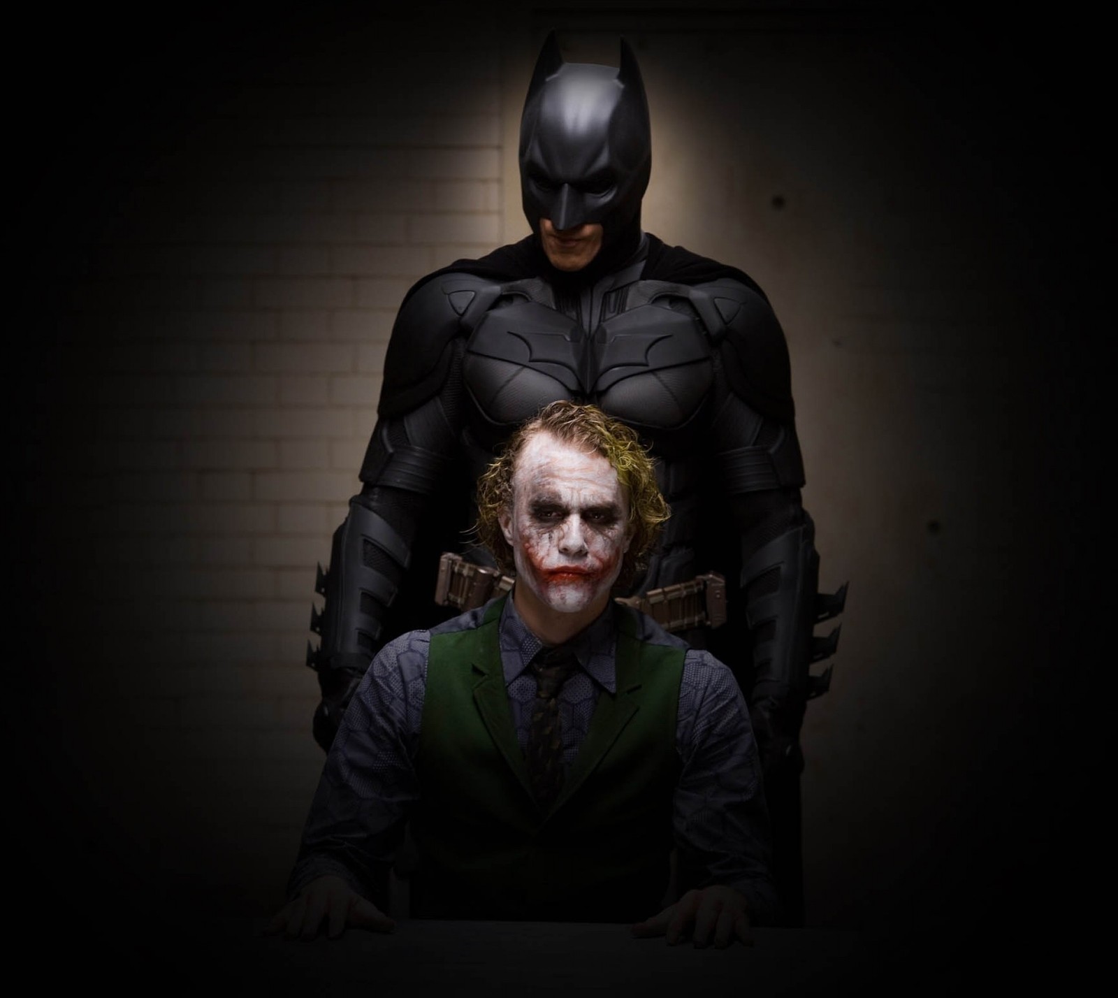 Batman and joker in a dark room with a brick wall (batman, dark knight, joker)