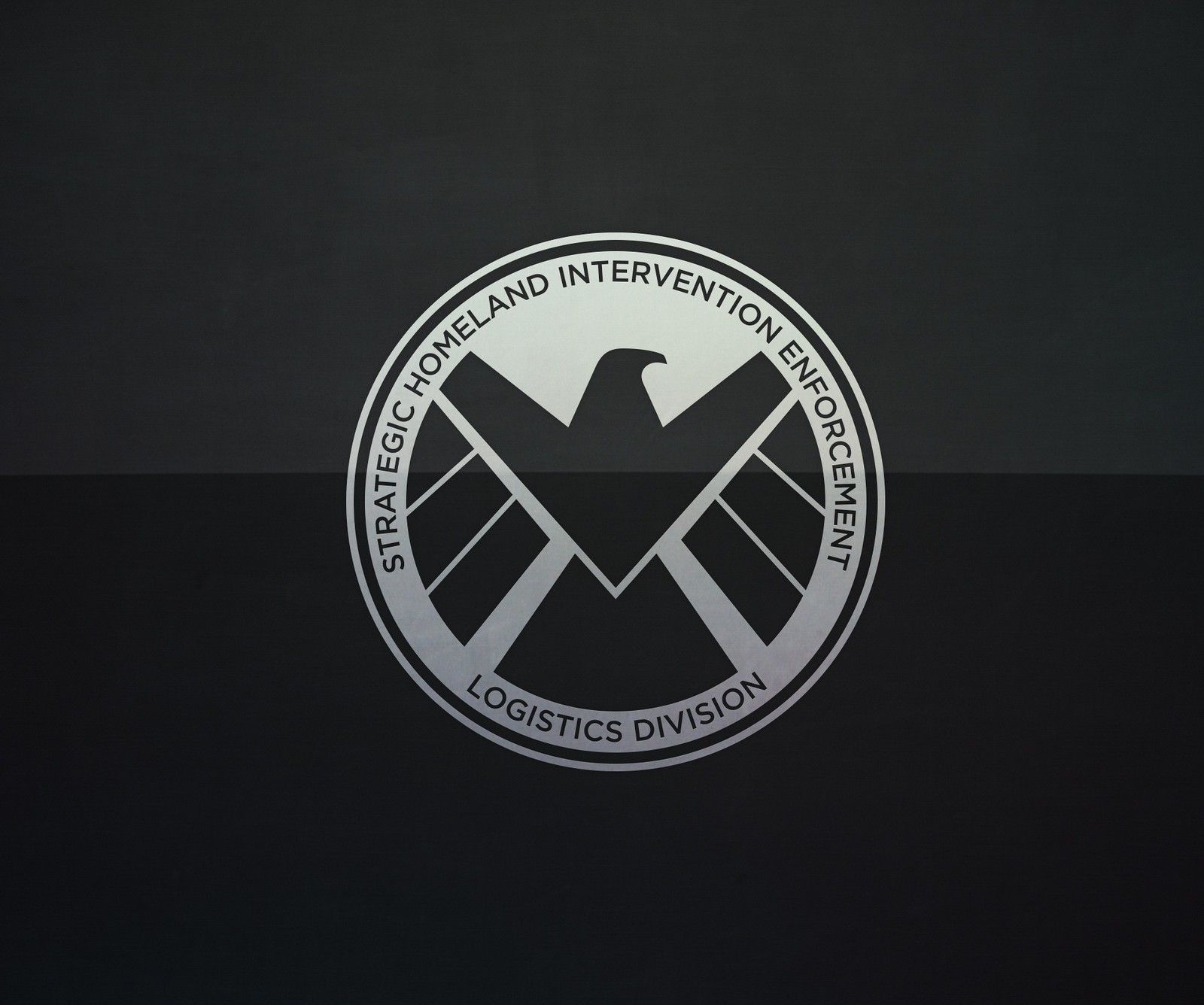 A close up of a logo on a black background (avengers, marvel, shield)