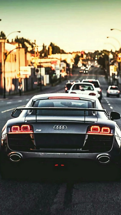 Elegante Audi R8 en una bulliciosa calle de la ciudad al atardecer.