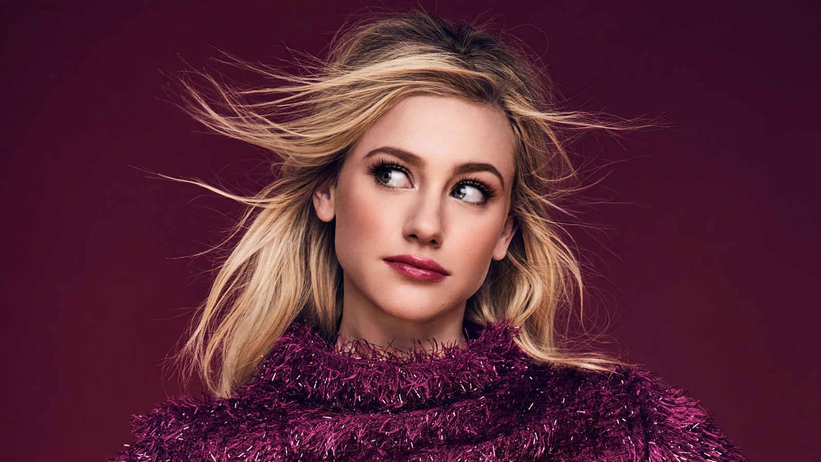 Un gros plan d'une femme portant un pull violet sur un fond rouge (lili reinhart, américain, actrice, célébrité, filles)